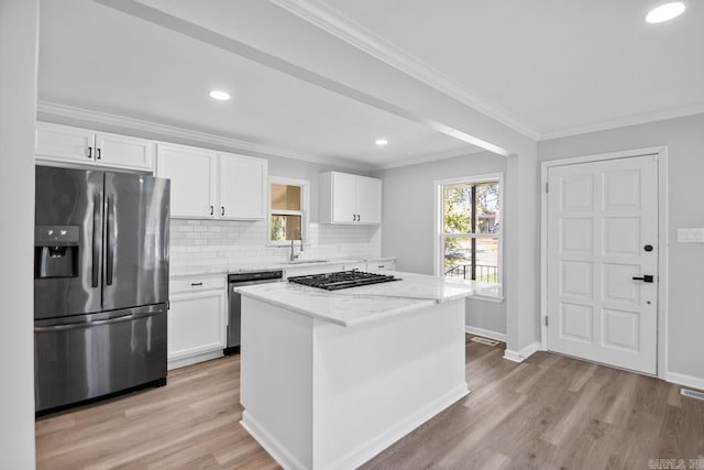 kitchen with light stone counters, white cabinets, and stainless steel appliances