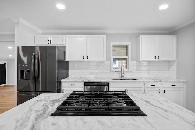 kitchen featuring white cabinets, ornamental molding, sink, backsplash, and appliances with stainless steel finishes