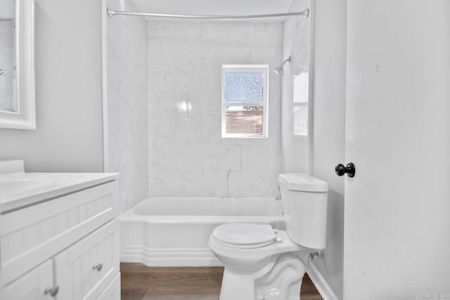 full bathroom featuring wood-type flooring, tiled shower / bath combo, vanity, and toilet