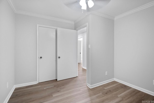 unfurnished bedroom featuring light hardwood / wood-style floors, ceiling fan, and crown molding