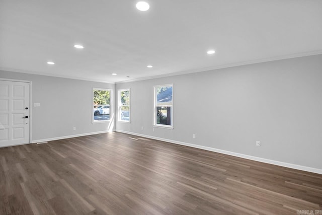 spare room featuring crown molding and dark wood-type flooring