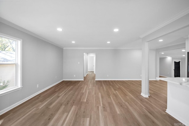 unfurnished living room featuring light wood-type flooring and ornamental molding