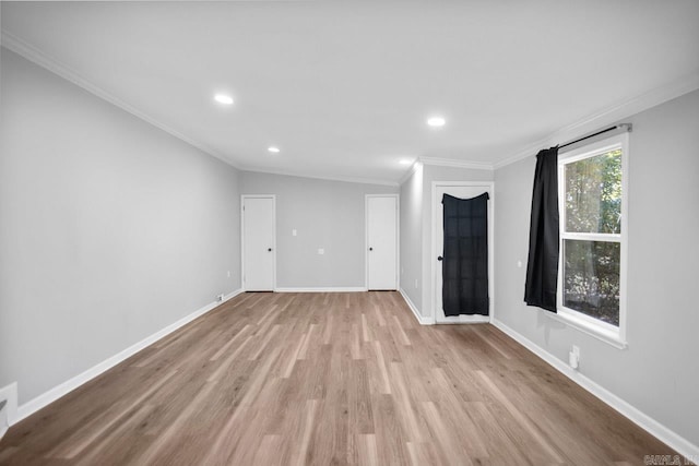 unfurnished room featuring light wood-type flooring, crown molding, and vaulted ceiling