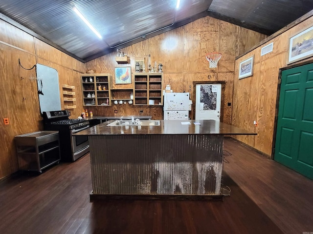 kitchen with lofted ceiling, stainless steel range with gas cooktop, and wooden walls