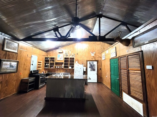 kitchen with lofted ceiling with beams, stainless steel gas stove, dark wood-type flooring, and ceiling fan