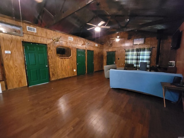 unfurnished living room with hardwood / wood-style floors, vaulted ceiling with beams, ceiling fan, and wooden walls