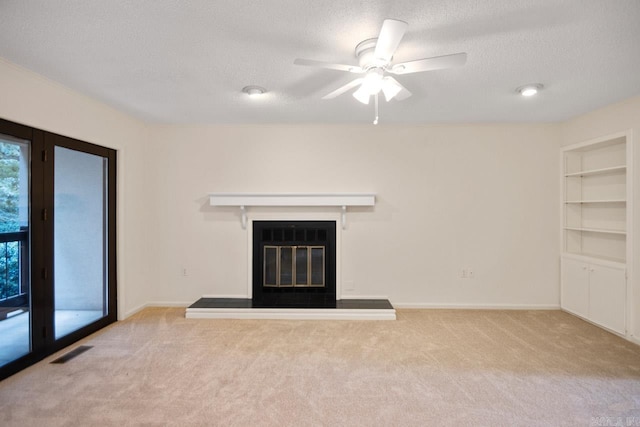 unfurnished living room with ceiling fan, light colored carpet, and a textured ceiling