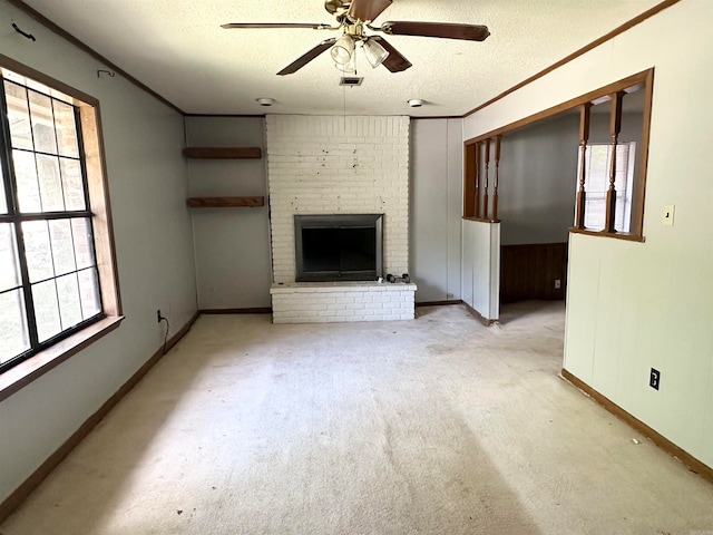 unfurnished living room featuring a healthy amount of sunlight, ceiling fan, a fireplace, and a textured ceiling