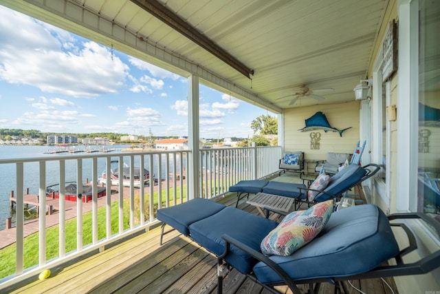 wooden terrace featuring a water view and ceiling fan