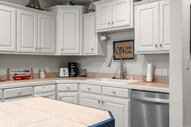 kitchen with white cabinets, dishwasher, tile countertops, and sink