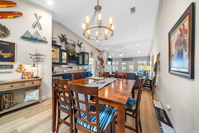 dining room featuring ceiling fan with notable chandelier, light hardwood / wood-style floors, and ornamental molding