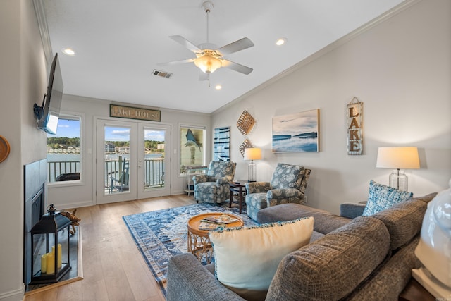 living room featuring light hardwood / wood-style flooring, ceiling fan, ornamental molding, and french doors