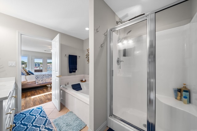 bathroom featuring independent shower and bath, vanity, french doors, and wood-type flooring