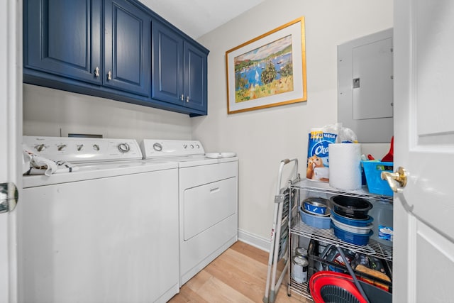 clothes washing area with light wood-type flooring, separate washer and dryer, electric panel, and cabinets