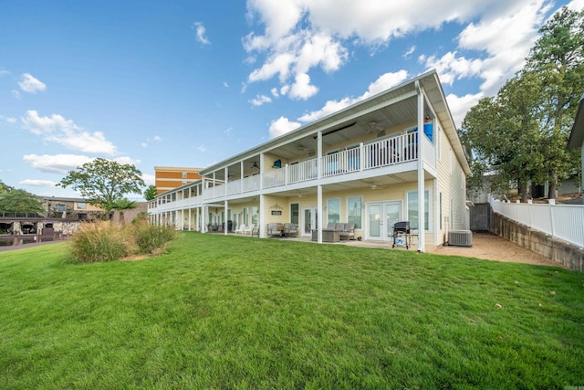 back of property featuring a balcony, a yard, a patio, and central air condition unit