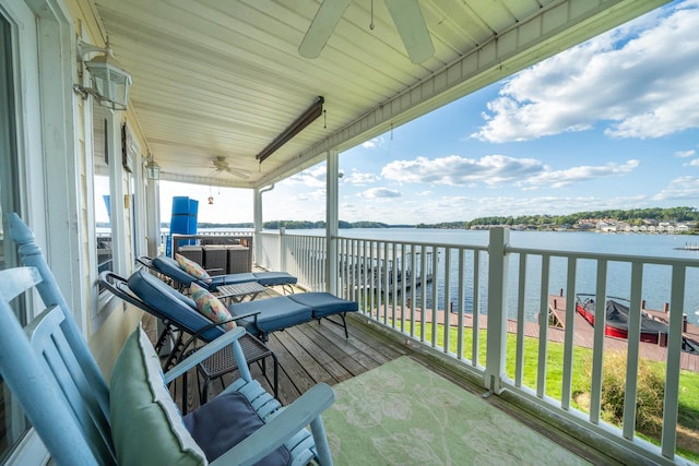 balcony featuring a water view and ceiling fan