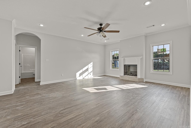 unfurnished living room with wood-type flooring, ornamental molding, and ceiling fan