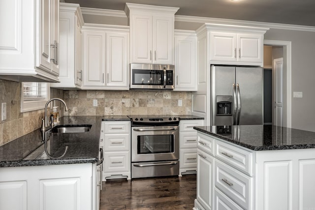 kitchen with stainless steel appliances, white cabinets, a center island, and sink