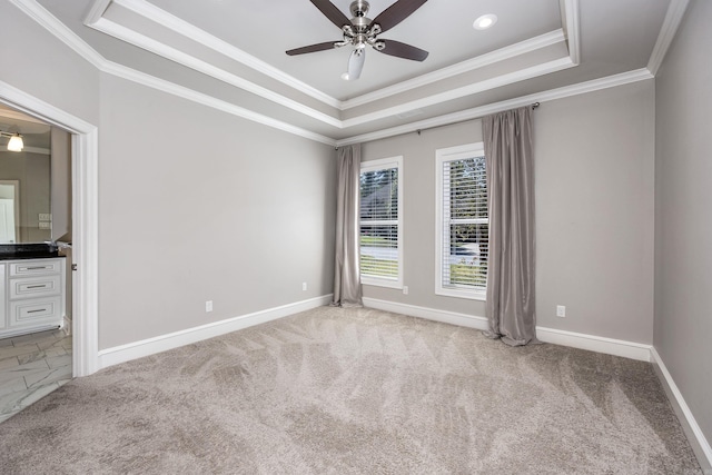 carpeted spare room featuring ceiling fan, a tray ceiling, and crown molding