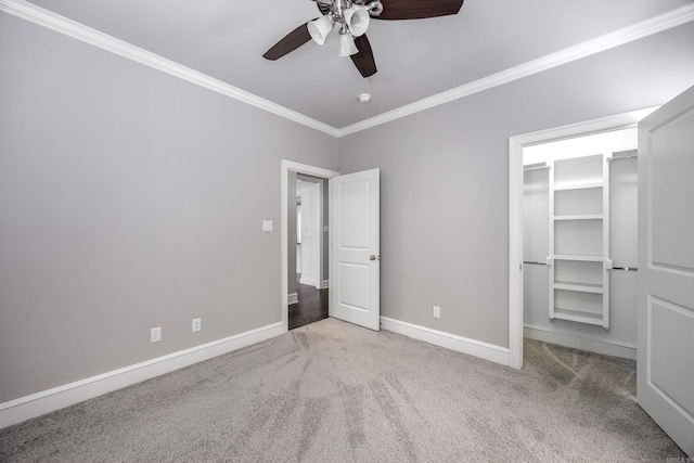 unfurnished bedroom with a closet, carpet, ceiling fan, and crown molding