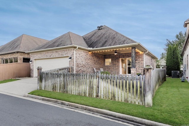 view of front facade featuring ceiling fan, a garage, a front lawn, and central AC