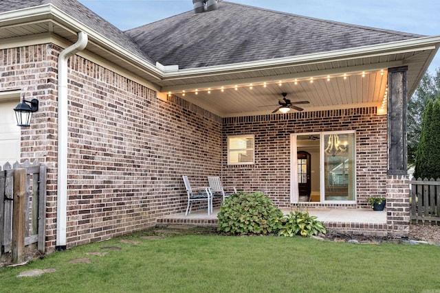 doorway to property featuring ceiling fan and a lawn