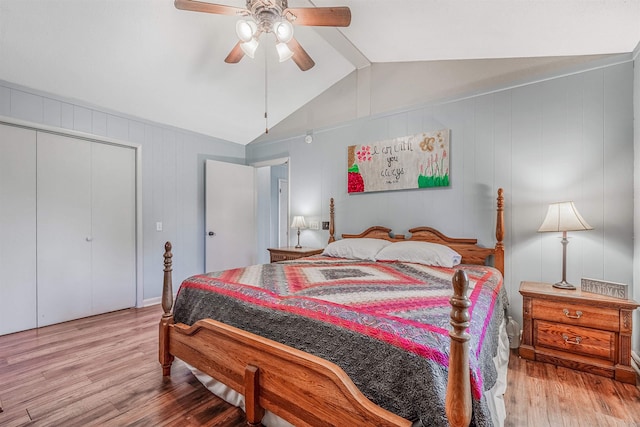 bedroom with a closet, vaulted ceiling, light hardwood / wood-style floors, and ceiling fan