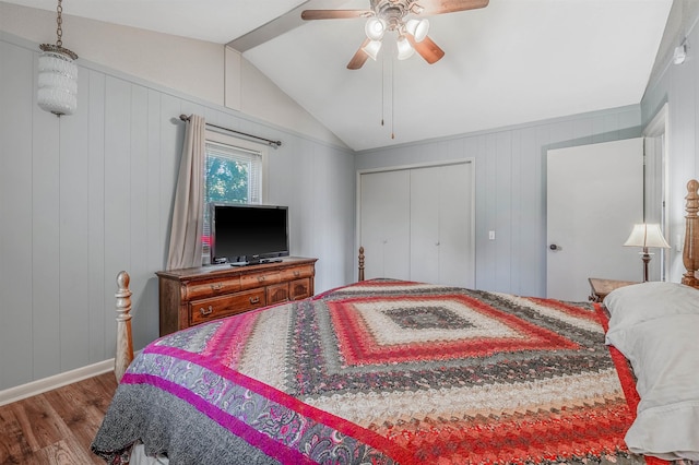 bedroom featuring ceiling fan, lofted ceiling, wood walls, a closet, and hardwood / wood-style floors