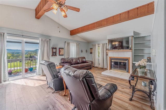 living room featuring vaulted ceiling with beams, light hardwood / wood-style floors, and plenty of natural light