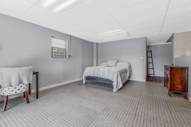 bedroom with cooling unit and a paneled ceiling