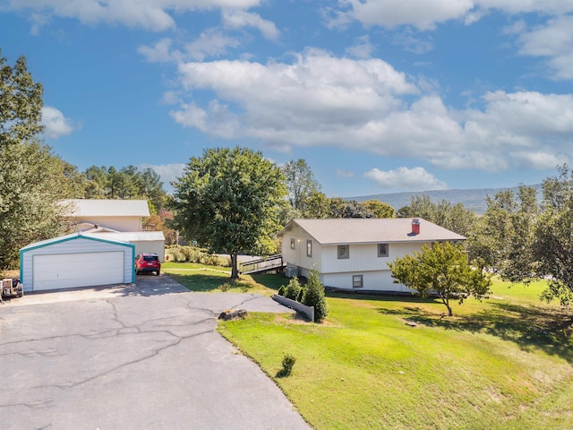 view of front of house featuring an outbuilding, a garage, and a front yard