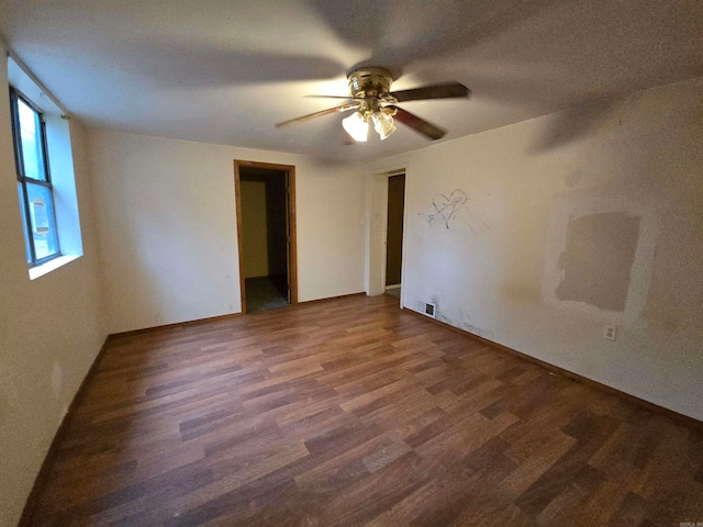 spare room featuring ceiling fan and dark hardwood / wood-style flooring