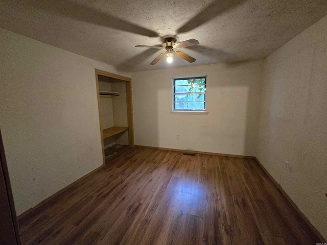 unfurnished bedroom with a textured ceiling, dark hardwood / wood-style floors, ceiling fan, and a closet