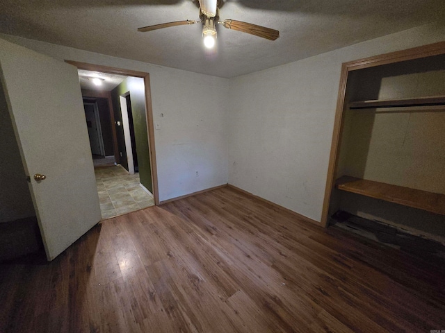 unfurnished bedroom featuring wood-type flooring, a closet, and ceiling fan