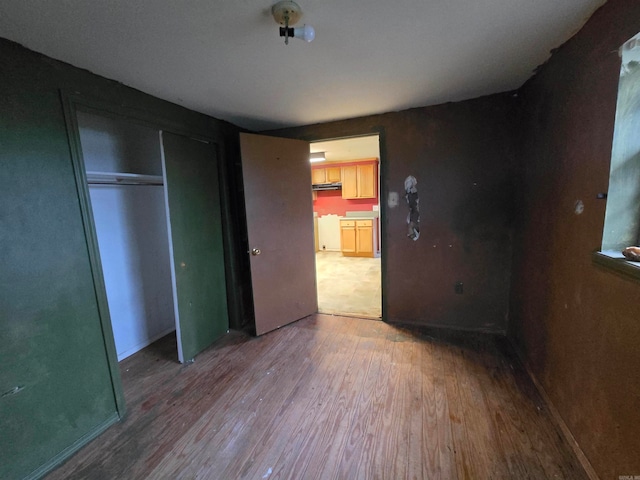 unfurnished bedroom featuring a closet and hardwood / wood-style floors