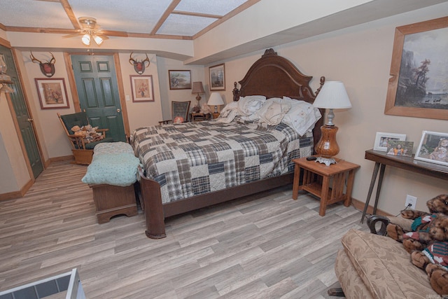 bedroom featuring a textured ceiling, light hardwood / wood-style floors, and ceiling fan