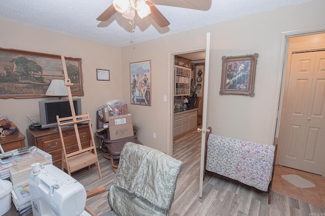 office area with ceiling fan, a textured ceiling, and light hardwood / wood-style floors