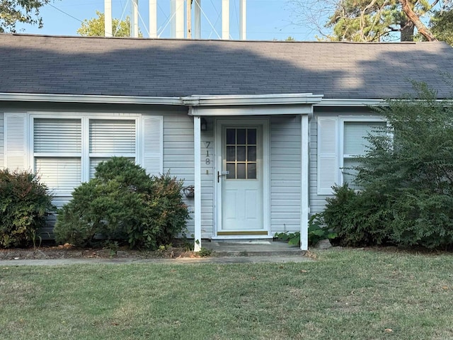 view of exterior entry with a lawn