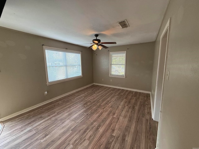 empty room with ceiling fan and dark wood-type flooring