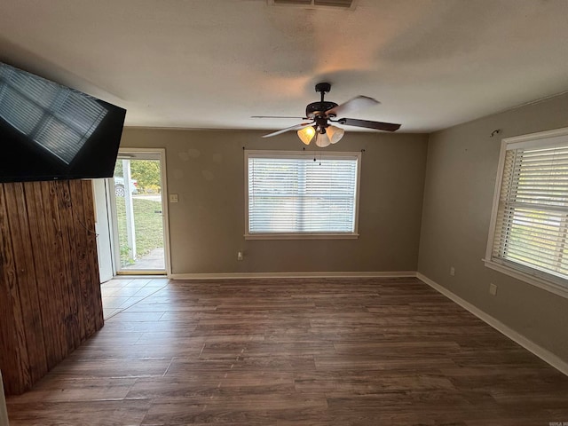 empty room with ceiling fan and dark hardwood / wood-style floors