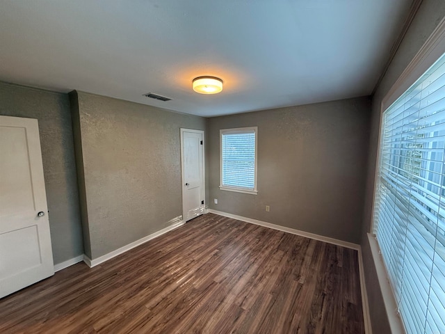 unfurnished room with dark wood-type flooring