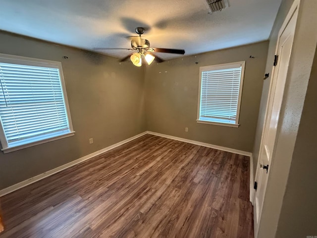 spare room with ceiling fan and dark hardwood / wood-style flooring