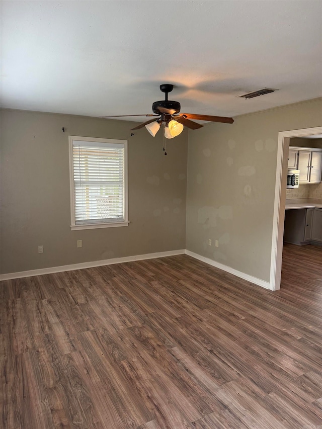 spare room with ceiling fan and dark hardwood / wood-style floors