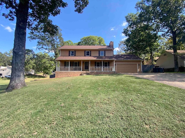 view of front of property with covered porch, a front yard, and a garage