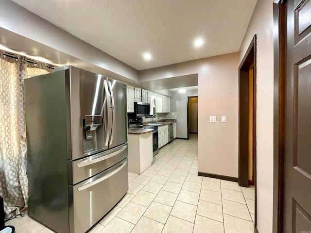 kitchen featuring light tile patterned floors, appliances with stainless steel finishes, sink, and white cabinetry