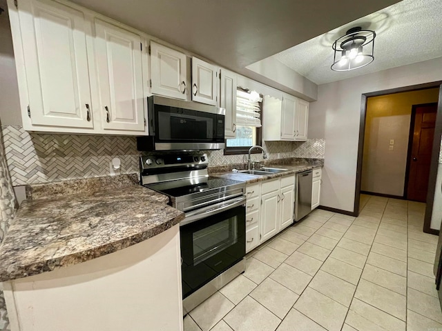 kitchen featuring appliances with stainless steel finishes, sink, tasteful backsplash, and white cabinetry