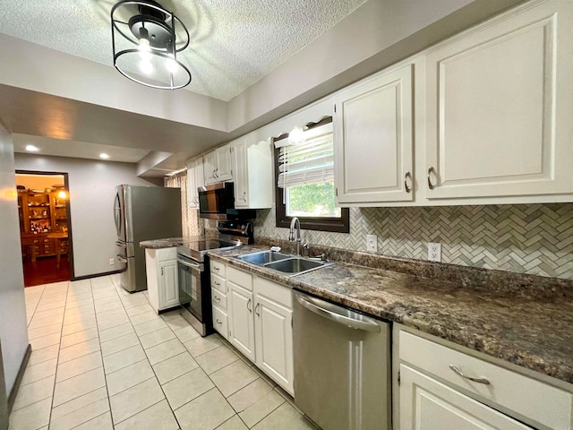 kitchen featuring backsplash, stainless steel appliances, white cabinets, and sink