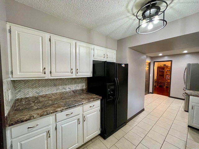 kitchen featuring white cabinets, black fridge, light tile patterned flooring, and stainless steel refrigerator