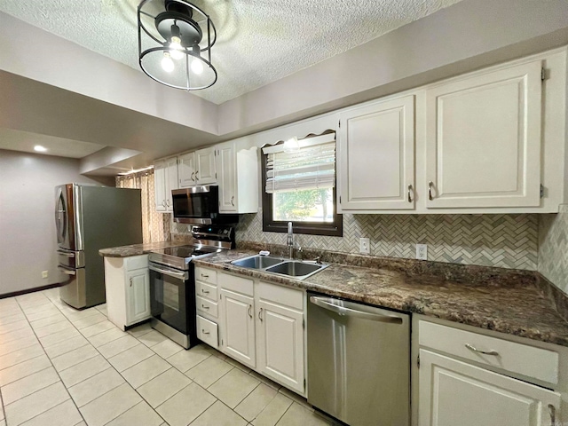 kitchen featuring white cabinets, light tile patterned flooring, sink, backsplash, and stainless steel appliances