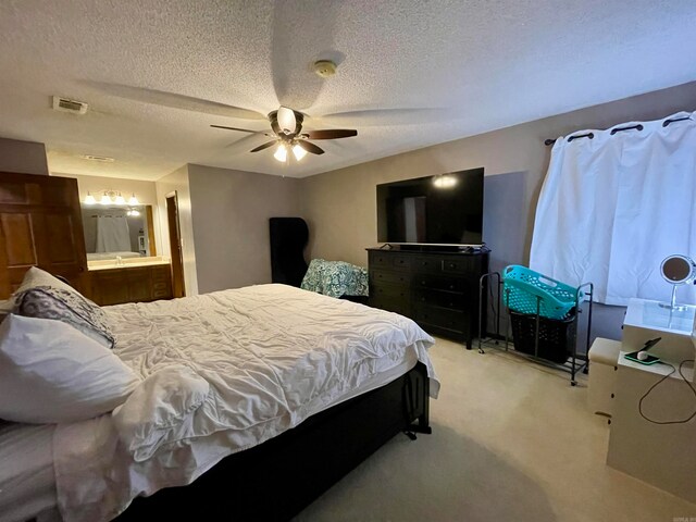 carpeted bedroom with a textured ceiling, ceiling fan, and ensuite bathroom